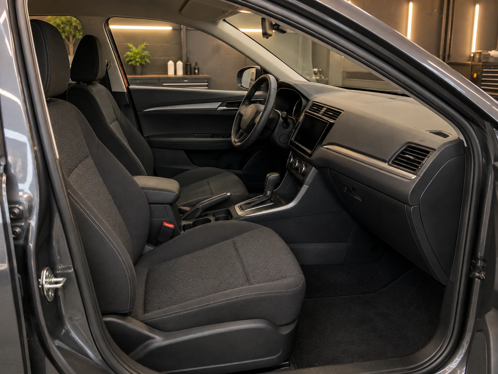 Interior do carro limpo, com bancos, carpete e painel higienizados